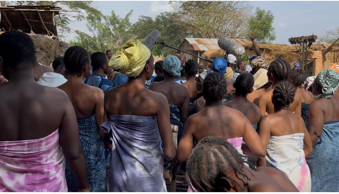 Village ensemble cast gathered on set with boom microphone